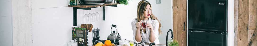 woman drinking coffee at kitchen counter