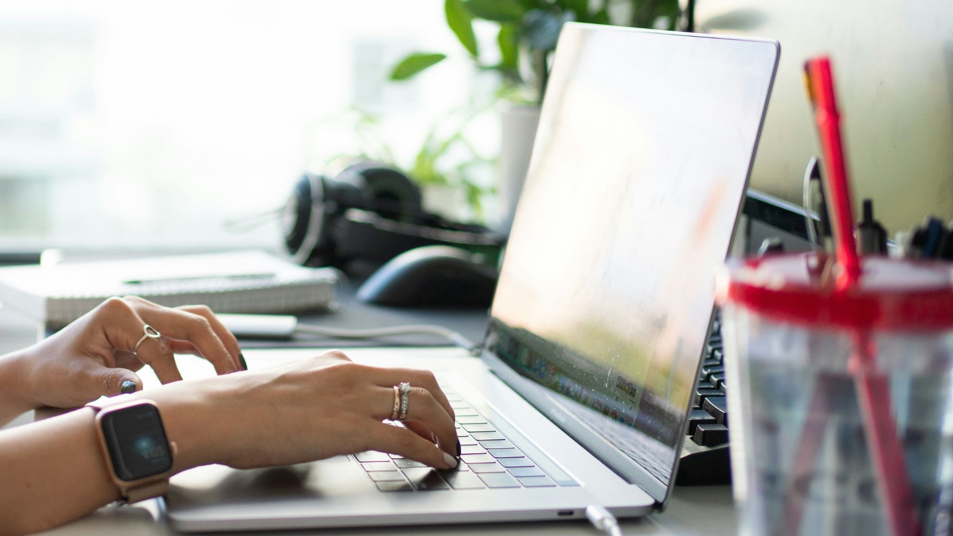 Person working from home at their desk in the sunlight.